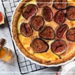 Tarte rustique aux figues, fromage savoyard et miel de Domancy sortie du four, servie chaude avec lamelles de lard fumé.