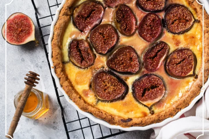 Tarte rustique aux figues, fromage savoyard et miel de Domancy sortie du four, servie chaude avec lamelles de lard fumé.