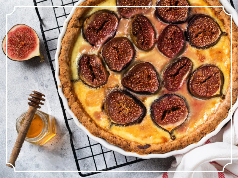 Tarte rustique aux figues, fromage savoyard et miel de Domancy sortie du four, servie chaude avec lamelles de lard fumé.